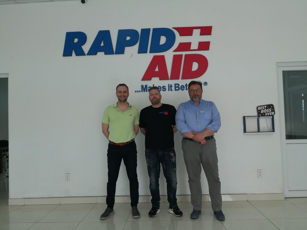 Andrea Volpe Filippo Bortoletti con imprenditore società RapidAid in piedi davanti all'ufficio. bacheca e porta a destra
